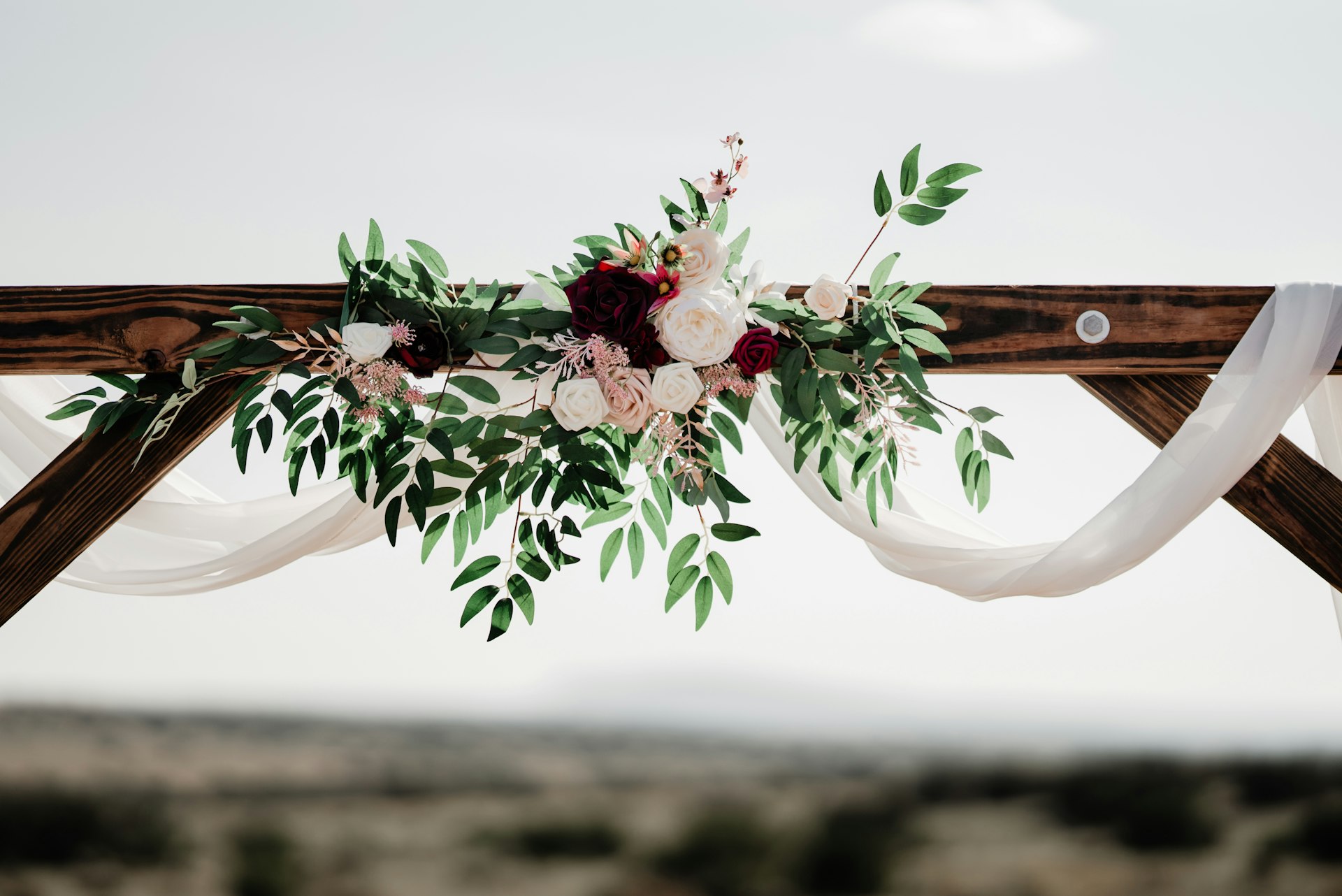 a wedding arch decorated with flowers and greenery